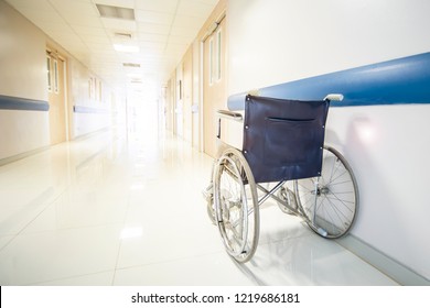 The wheel chair parking in hospital walk way.Empty wheel chair with white and bright background with warm tone white balance. - Powered by Shutterstock