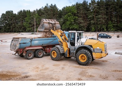 Wheel front loader or bulldozer at a construction site in a quarry. Powerful modern equipment for earthworks. Construction site.