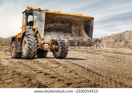 Wheel front loader or bulldozer at a construction site in a quarry. Powerful modern equipment for earthworks. Construction site. Rental of construction equipment