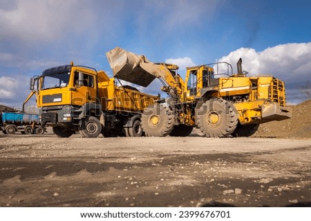 Wheel front loader or bulldozer at a construction site in a quarry. Powerful modern equipment for earthworks. Construction site. Rental of constructio
