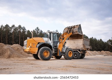 Wheel front loader at a construction site in a quarry. Powerful modern equipment for earthworks. Construction site. Heavy wheel loader at work.