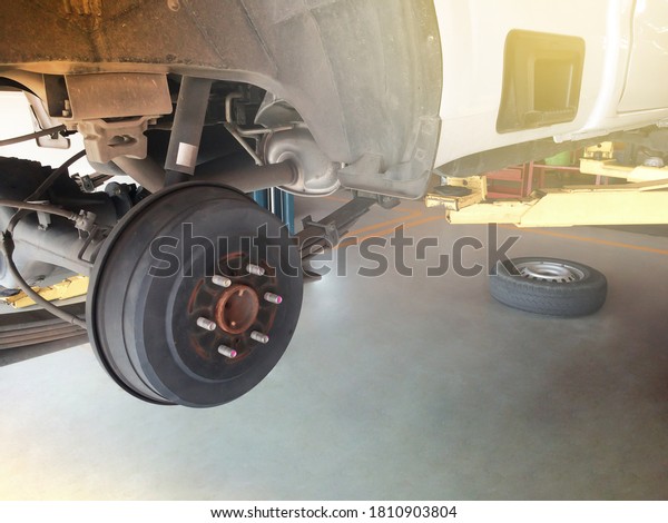 Wheel hub and truck tire in process of changing and\
maintenance pickup truck wheel alignment in service in a garage.\
Focus on wheel hub.