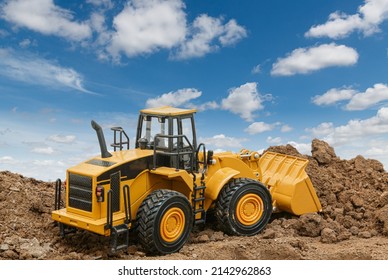 Wheel loader are digging the soil in the construction site on the clouds and sky background . - Shutterstock ID 2142962863