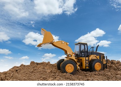 Wheel loader are digging the soil in the construction site on sky background ,with white fluffy cloud - Shutterstock ID 2158373745