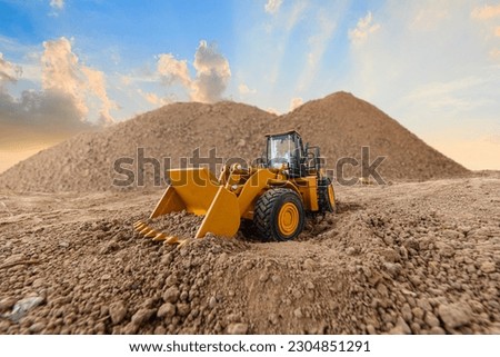 Wheel loader are digging the soil in construction site  on sunset background