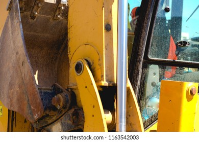 Wheel Loader Excavator With Backhoe Cab , Stick And Bucket Boom  In Construction Site Quarry With Detail Of Hydraulic Bulldozer Piston Excavator Arm On A City Streets Background . Industrial Close-up
