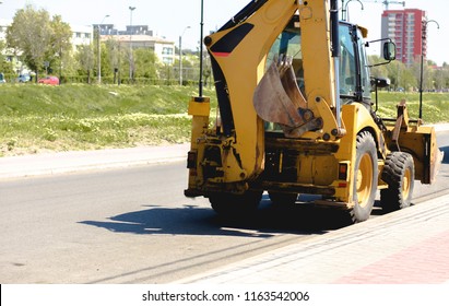 Wheel Loader Excavator With Backhoe Cab , Stick And Bucket Boom  In Construction Site Tractor With Detail Of Hydraulic Bulldozer Piston Excavator Arm On A City Streets Background. Industrial Close-up
