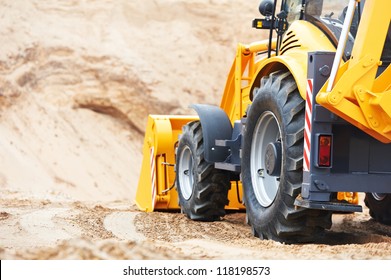 Wheel Loader Excavator With Backhoe Unloading Sand At Eathmoving Works In Construction Site Quarry