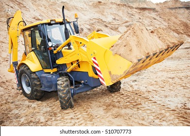 Wheel loader excavator with backhoe unloading sand at eathmoving works in construction site quarry