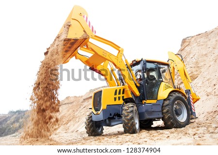 Wheel loader Excavator with backhoe unloading sand at eathmoving works in construction site