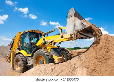 Wheel loader Excavator unloading sand with water during earth moving works at construction site