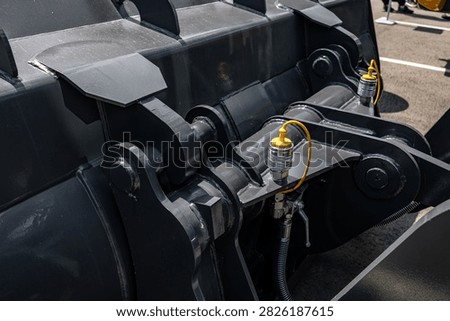 Wheel loader front bucket quick coupler hydraulic connections. Modern construction machinery attachment mechanism linkage with quick disconnect plugs and technical transport vehicle details.