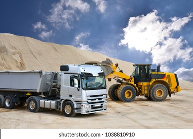 Wheel Loader Loads A Truck With Sand In A Gravel Pit 