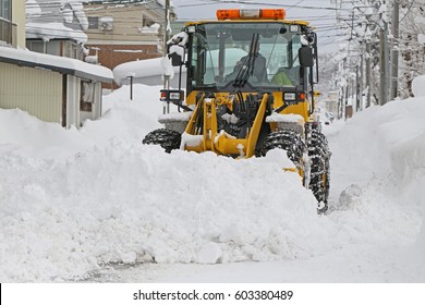 Wheel loader machine removing snow in winter