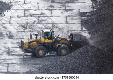 WHEEL LOADER - Machine at work on the yard of a coal storage site in rainy weather
