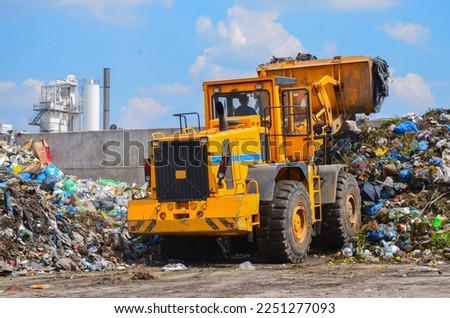 Wheel loader on landfill. Sorting rubbish by wheel loader
