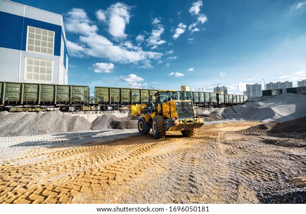 Wheel loader picks rubble into\
the bucket. Work on a flyover for unloading railway freight cars.\
Transportation of inert materials for concrete\
production.