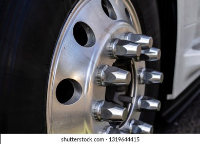 The Wheel Of Long Haul American Logistic Freight Leader Transportation Big Rig Semi Truck With Tire Aluminum Rim And Chrome Mounting Bolts Mounted On The Truck Axle