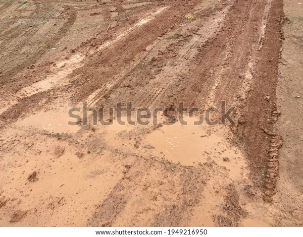 The\
wheel marks on the muddy road in a construction\
site