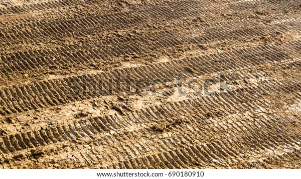 wheel\
marks of tractor  on the ground texture\
background
