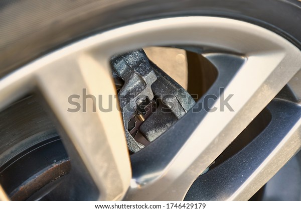 Wheel of modern SUV vehicle, break caliper and\
rotor, car detail closeup
