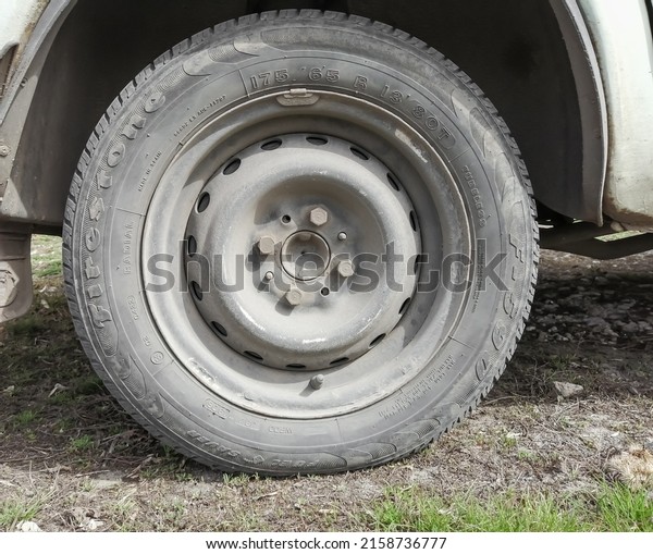 A wheel on a car.\
The whole wheel is in the frame. on Zhiguli. A gray, dirty wheel.\
Wheel size 165x75.