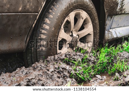 the wheel of a passenger car stuck in the mud on an off-road
