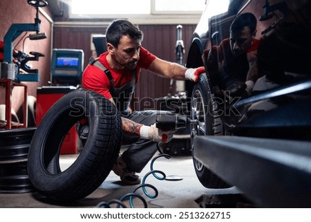 Wheel repairman using tool to remove damaged tire from the car.