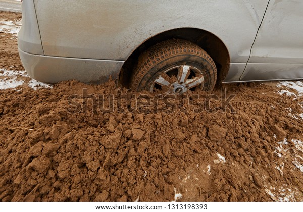 The
wheel of a silver car stuck in the sand, can not
go