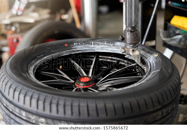 Wheel with tire on tire changing machine in auto
repair service.
