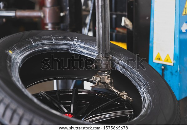 Wheel with tire on tire changing machine in auto\
repair service.