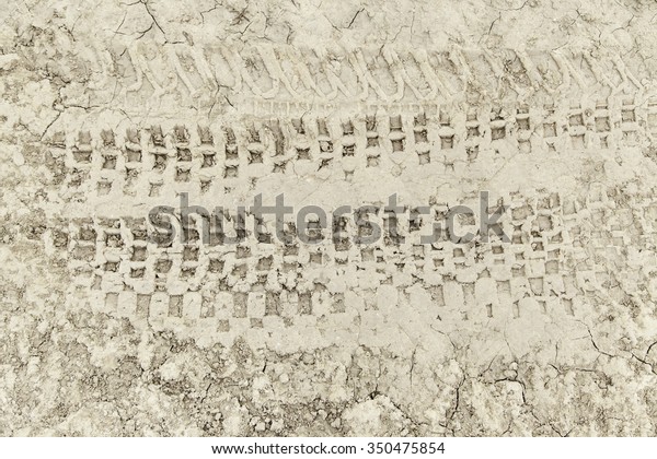 Wheel tracks in\
the mud, detail footprints\
Car