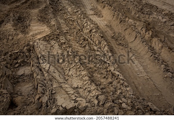 Wheel trail on sandy ground from large\
transport, tractor on construction site, sandy\
road