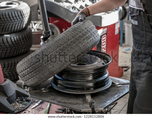 Wheel whit summer tire on tire\
changing machine in a workshop. Wheel on tire changing\
machine.