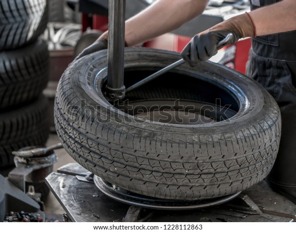 Wheel whit summer tire on tire\
changing machine in a workshop. Wheel on tire changing\
machine.
