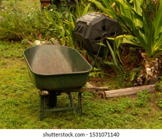 Wheelbarrow And Compost Maker Tumbler In The Garden