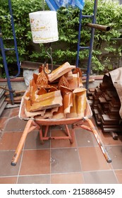 wheelbarrow containing shiny tiles for Buddhist temple roof, Buddhist temple renovation site in Thailand