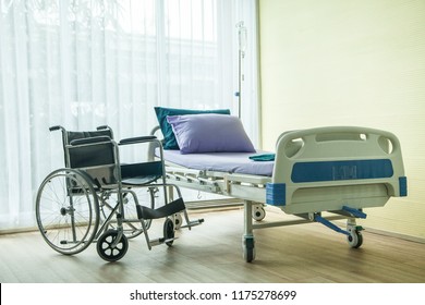 Wheelchair And Bed In The Hospital Waiting Used For Sick People. The Bed Near Window Have Light From Sun Shine