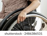 A wheelchair. Close-up of the hands of a child steering a wheelchair. The concept of people with disabilities.