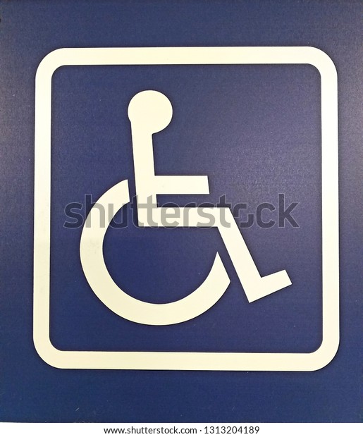 \
Wheelchair disabled symbol parking permit\
signal white painted on the street for handicapped person, Outdoor\
place no people, no car on a blue\
background.