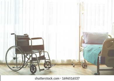 Wheelchair And Patient Bed Iv Saline Bag Infusion Set And Bottle On A Pole. Fluid Saline Drip Hospital Room Or Clinic. Medical Concept, Treatment Emergency Shock.  Waiting For Patient Services. 