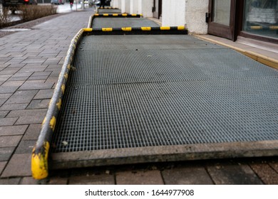 WHEELCHAIR RAMP With Grid,  Yellow Warning Lines On Sides. Shops, Offices And Service Providers. Street And Building Facade