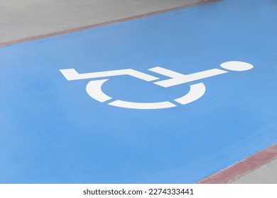 Wheelchair symbol on asphalt road. Disabled parking permit