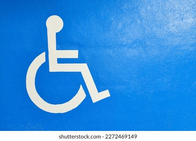 wheelchair symbol in white on a blue background for garage spaces accessible to people in wheelchairs