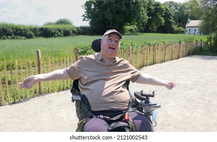 Wheelchair user sitting in the sun with his arms spread