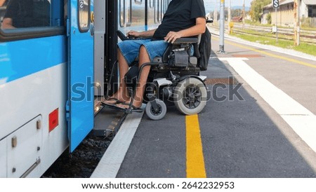 Wheelchair user using accessible train travel approaches a train at a station while preparing to board. It's a sunny day, ensuring a smooth transition onto the train.