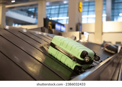 Maleta con ruedas en un cinturón de equipaje en la terminal del aeropuerto.