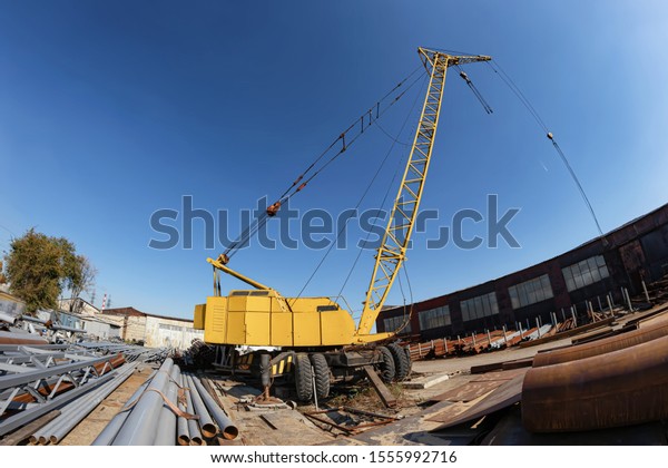 Wheeled truck crane\
for loading heavy metal in the warehouse of the production base of\
metal structures