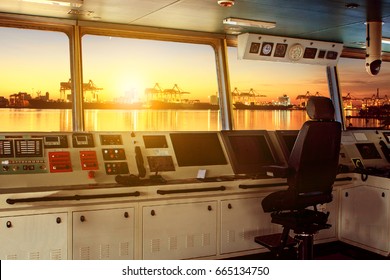 wheelhouse control board of modern industry ship approaching to harbor at night