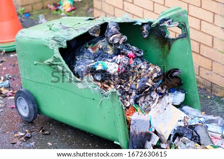 Wheelie bin vandalism on side burnt out by fire by vandals in council estate London arson attack